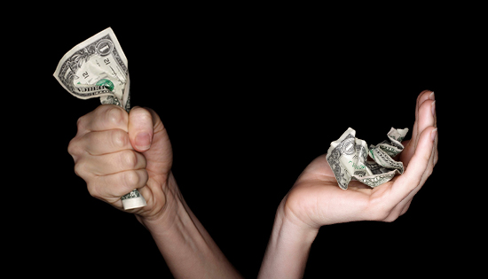 two hands hold dollar bills
