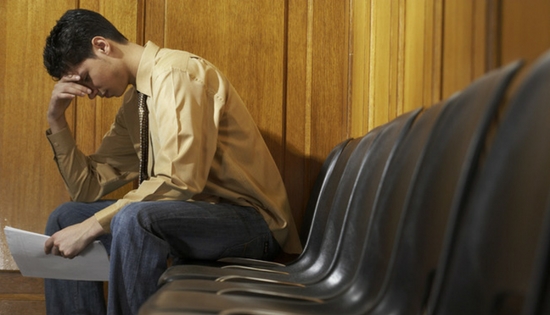 young man looking despondent hold a paper