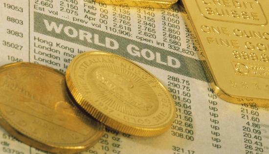 gold coins and bullions laying on a newspaper