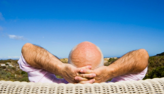 Older man lounging with his hands behind his head