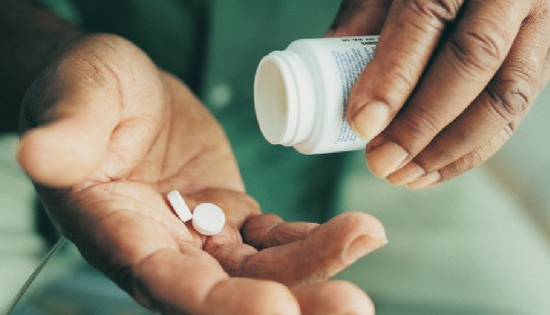 someone pouring pills from a bottle into their hands