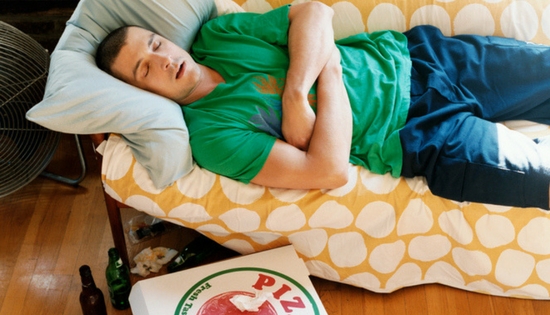 young man laying on couch in the middle of the day