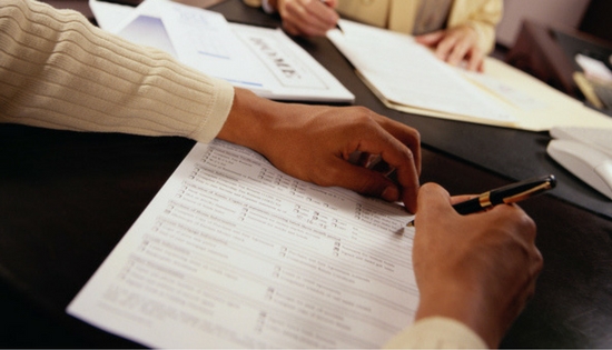 man signing paper work for a loan