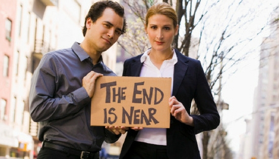 man and woman holding a sign that says the end is near