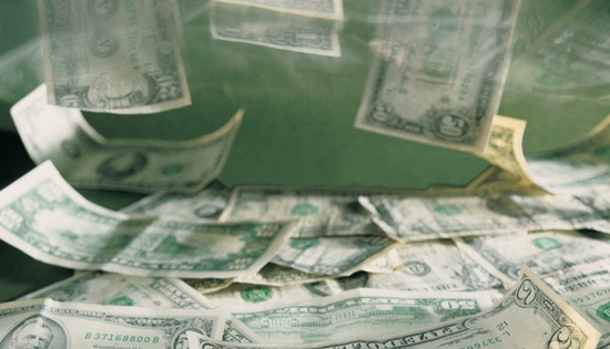 cash being dropped into a tank full of water
